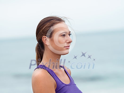 Sporty young woman standing on the sea coast Sporty young woman standing on the sea coast