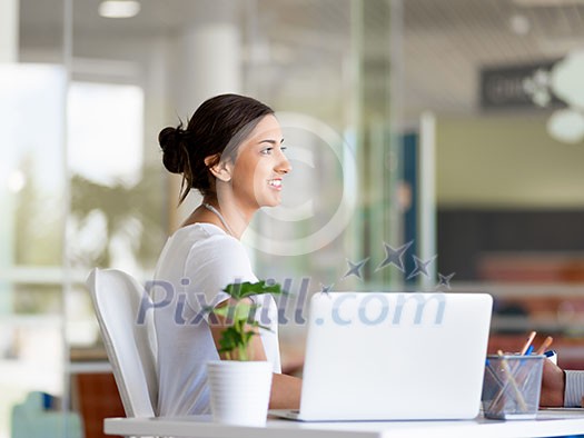 Happy and confident young woman in an office Happy and confident young woman in an office