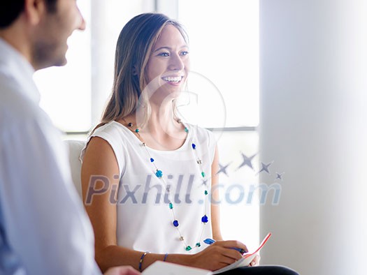 Young business woman talking to her collegue and smiling Young business woman talking to her collegue and smiling