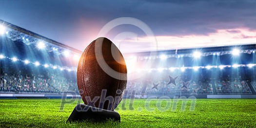 American football stadium and ball on green grass. Mixed media American football stadium and ball on green grass. Mixed media