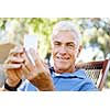 Handsome senior man outdoors using mobile phone