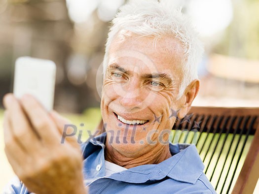 Handsome senior man outdoors using mobile phone Handsome senior man outdoors using mobile phone