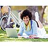 Woman working outdoors in park with laptop
