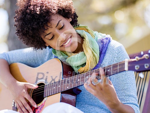 Young pretty woman playing guitar in park Young pretty woman playing guitar in park