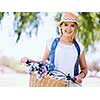 Happy young woman with bicycle in the park