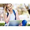 Woman working outdoors in park with laptop