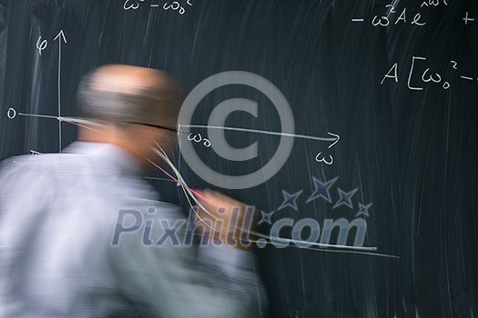 Math teacher drawing fuction graph on a blackboard during mathclass (motion blurred image) Math teacher drawing fuction graph on a blackboard during mathclass (motion blurred image)