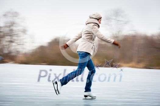 Young woman ice skating outdoors on a pond on a freezing winter day Young woman ice skating outdoors on a pond on a freezing winter day