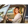 Pretty, young woman  driving a car -Invitation to travel. Car rental or vacation.