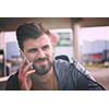 handsome young casual business man with beard using cell phone and smile outdoor on city street