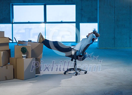 young businessman on construction site taking a break while checking documents and business workflow with cardboard boxes around him in new startup office young businessman on construction site taking a break while checking documents and business workflow with cardboard boxes around him in new startup office