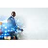 Digital schemes and graphs with businessman walking and smiling.