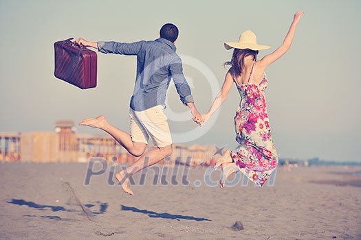 couple on beach with travel bag representing freedom and funy honeymoon concept couple on beach with travel bag representing freedom and funy honeymoon concept