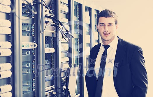 young it engeneer business man with thin modern aluminium laptop in network server room young it engeneer business man with thin modern aluminium laptop in network server room