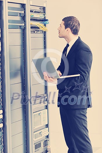young it engeneer business man with thin modern aluminium laptop in network server room young it engeneer business man with thin modern aluminium laptop in network server room