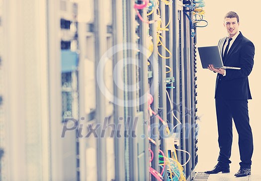 young it engeneer business man with thin modern aluminium laptop in network server room young it engeneer business man with thin modern aluminium laptop in network server room