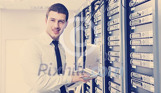 young it engeneer business man with thin modern aluminium laptop in network server room young it engeneer business man with thin modern aluminium laptop in network server room