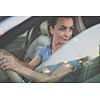 Pretty, young woman  driving a car -Invitation to travel. Car rental or vacation.