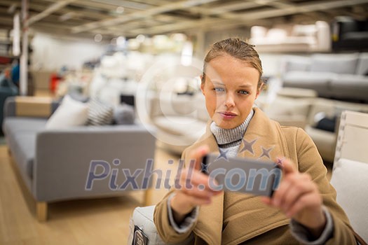 Pretty, young woman choosing the right furniture for her apartment in a modern home furnishings store (color toned image; shallow DOF) Pretty, young woman choosing the right furniture for her apartment in a modern home furnishings store (color toned image; shallow DOF)