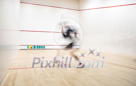Squash player in action on a squash court (motion blurred image; color toned image) Squash player in action on a squash court (motion blurred image; color toned image)