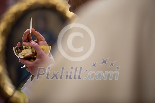 Priest during a wedding ceremony/nuptial mass (shallow DOF; color toned image) Priest during a wedding ceremony/nuptial mass (shallow DOF; color toned image)