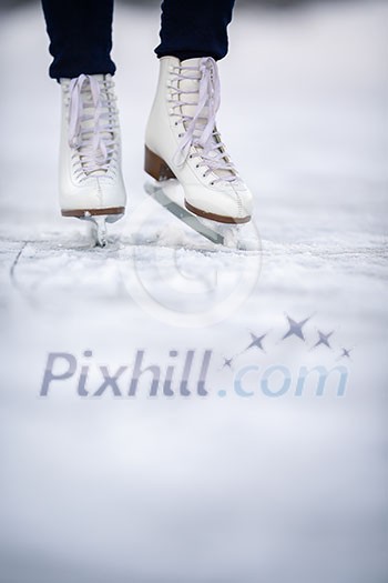 Young woman ice skating outdoors on a pond on a freezing winter day Young woman ice skating outdoors on a pond on a freezing winter day
