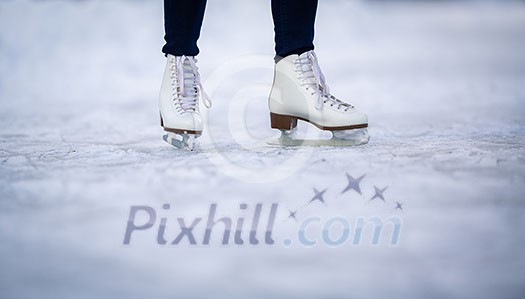 Young woman ice skating outdoors on a pond on a freezing winter day - detail of the skates Young woman ice skating outdoors on a pond on a freezing winter day - detail of the skates