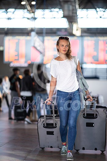 Young woman with her luggage at an international airport, before going through the check-in and the security check before her flight Young woman with her luggage at an international airport, before going through the check-in and the security check before her flight