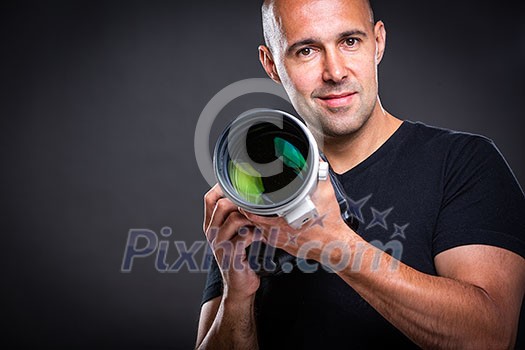 Young, pro male photographer in his studio during a photo shoot (color toned image; shallow DOF) Young, pro male photographer in his studio during a photo shoot (color toned image; shallow DOF)