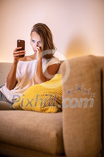Cute young woman on a comfortable sofa in her modern apartment using her cell phone Cute young woman on a comfortable sofa in her modern apartment using her cell phone