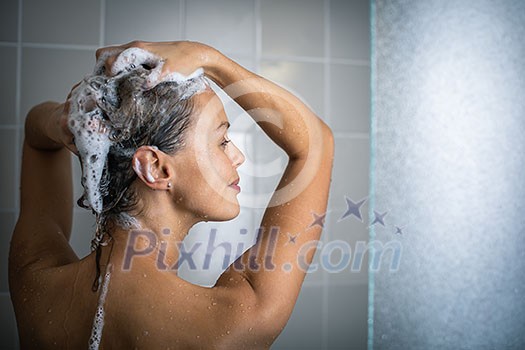 Woman taking a long hot shower washing her hair in a modern design bathroom Woman taking a long hot shower washing her hair in a modern design bathroom