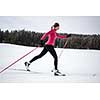 Cross-country skiing: young woman cross-country skiing on a winter day (motion blurred image)