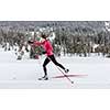 Cross-country skiing: young woman cross-country skiing on a winter day (motion blurred image)
