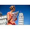 Gorgeous female tourist with map admiring the Leaning Tower of Pisa, Tuscany, Italy (shallow DOF)