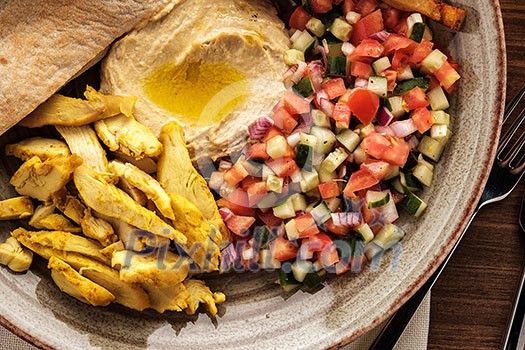 Shwarma in a plate with hummus and salad
