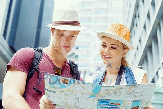 Happy young couple as tourists with a map Happy young couple as tourists with a map
