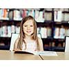 Little girl reading books in library