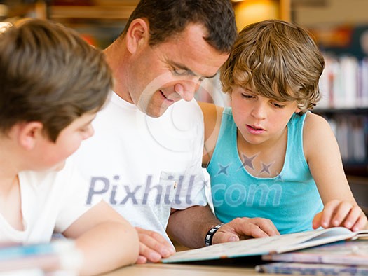 Father with sons in library with books Father with sons in library with books
