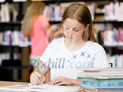 Teenage girl with books studying in library Teenage girl with books studying in library