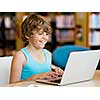 Little boy with laptop in library