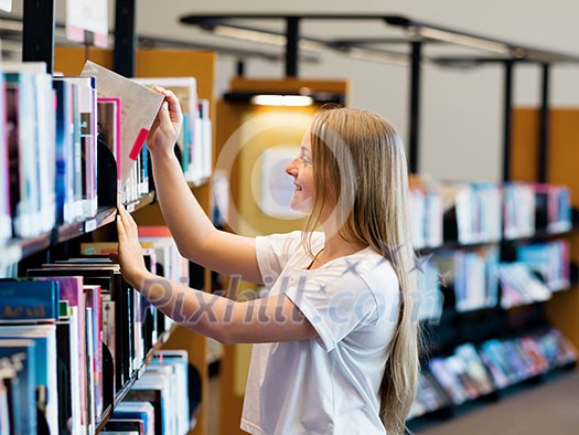 teenage girl in library choosing books teenage girl in library choosing books