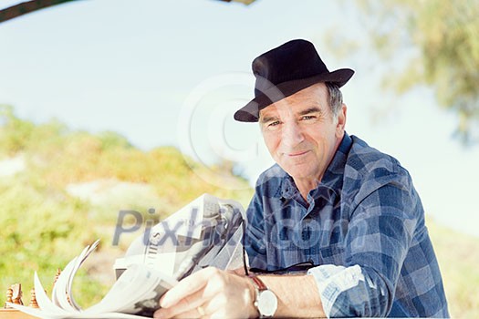 Senior gentleman reading newspaper in park Senior gentleman reading newspaper in park
