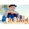 Elderly man sitting outdoors with chess