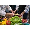 Professional team cooks and chefs preparing meal at busy hotel or restaurant  kitchen