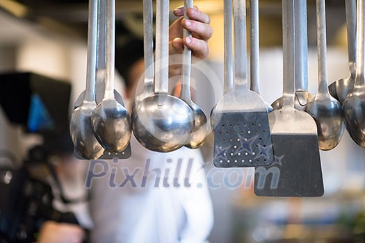 professional Cooking utensils hanging in a restaurant kitchen professional Cooking utensils hanging in a restaurant kitchen