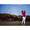golf player hitting shot with driver on course at beautiful sunny day