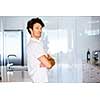 Portrait of a smart young man with curly hair standing in kitchen