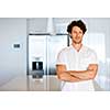 Portrait of a smart young man with curly hair standing in kitchen