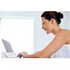 Young beautiful woman sitting at the table and working on her laptop