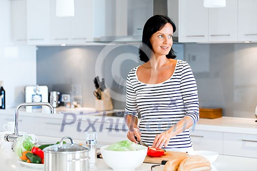 Image of beautiful woman standing in the kitchen and smiling Image of beautiful woman standing in the kitchen and smiling